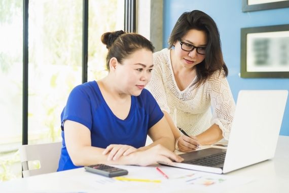 Two business women are working with computer in the office